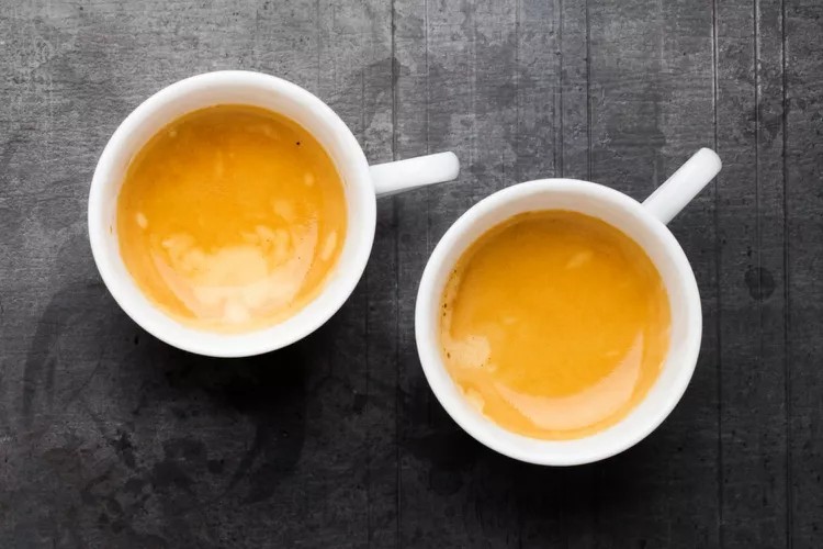 A close-up of a perfect espresso crema with a rich, golden-brown color.