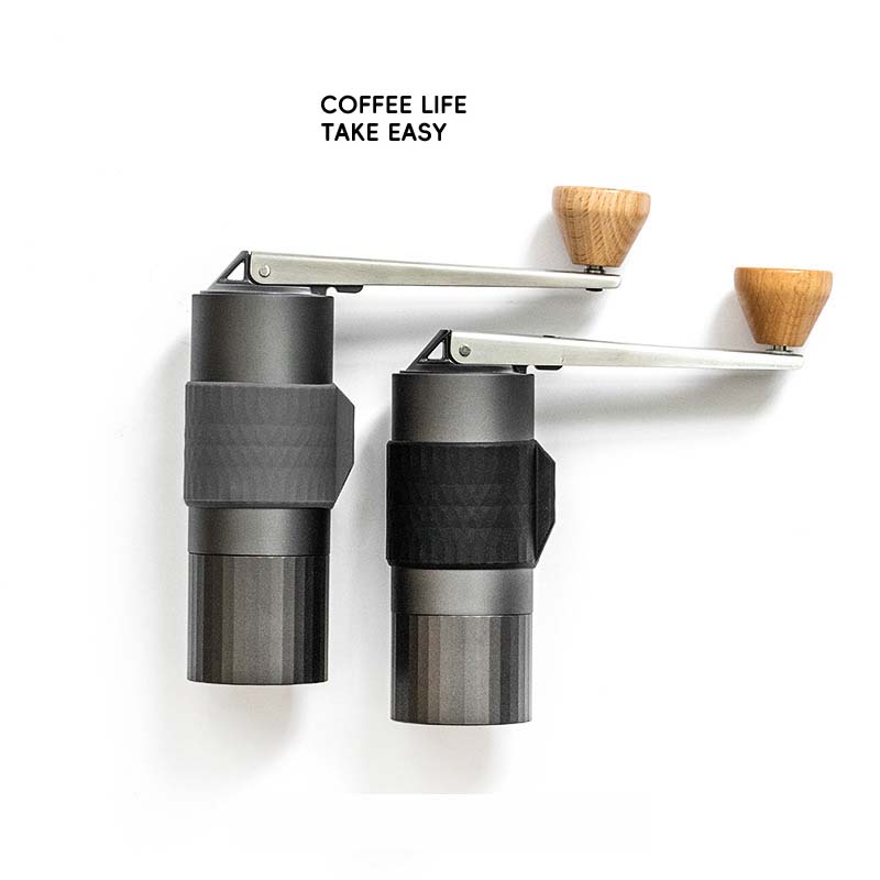 Artisan Grind AC90 being held, showcasing its foldable handle and compact design.